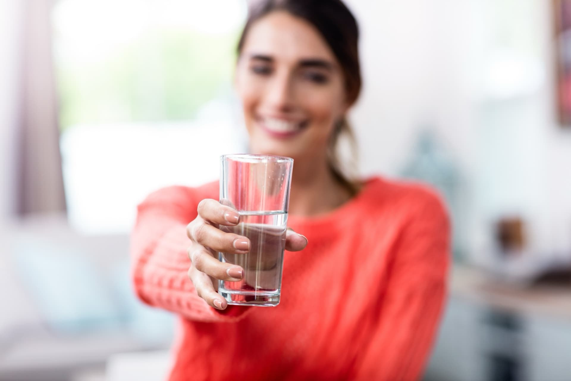 Woman holding glass of clean water